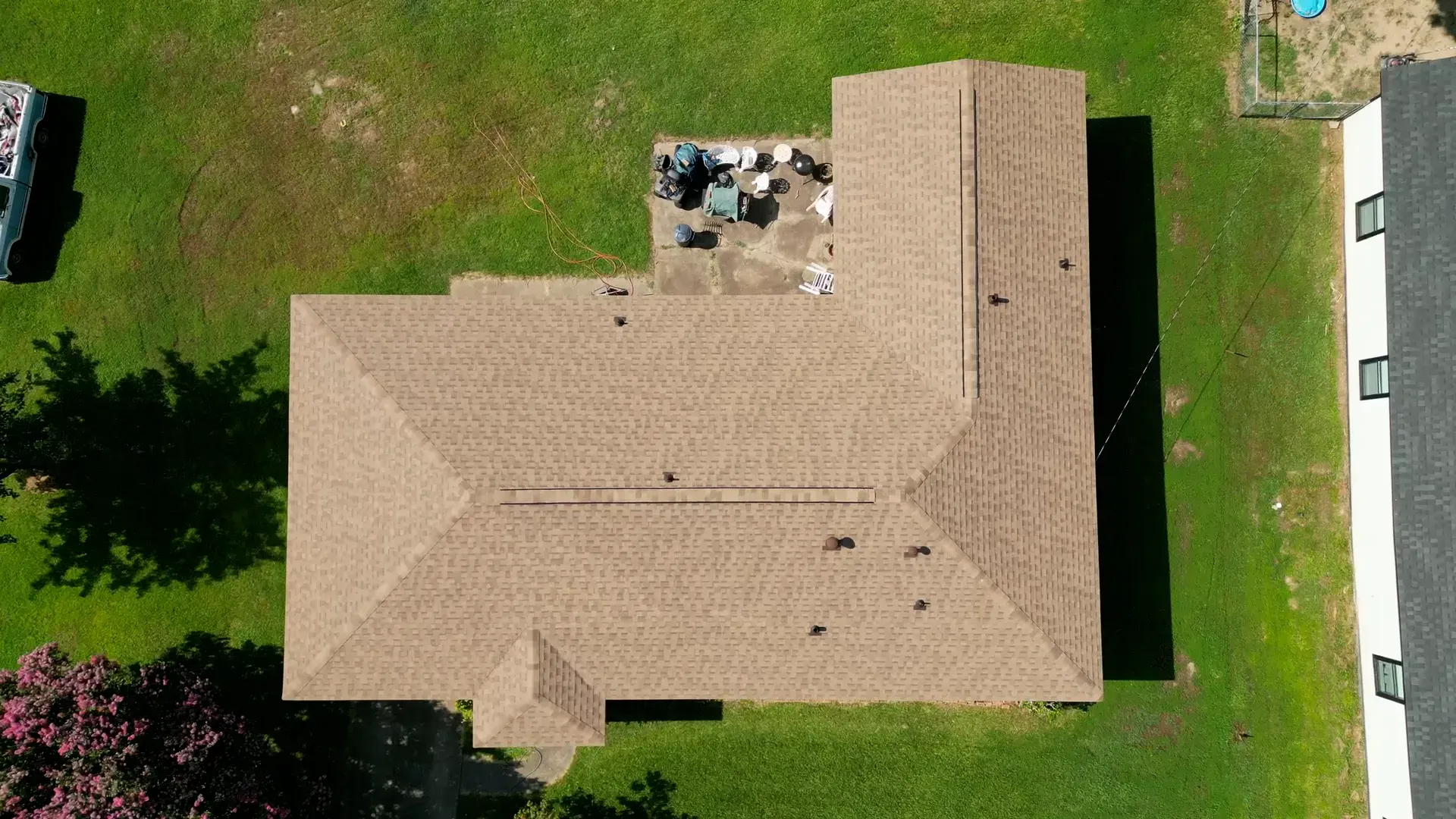 Top-down aerial view of a newer suburban home with a clean tan hip roof